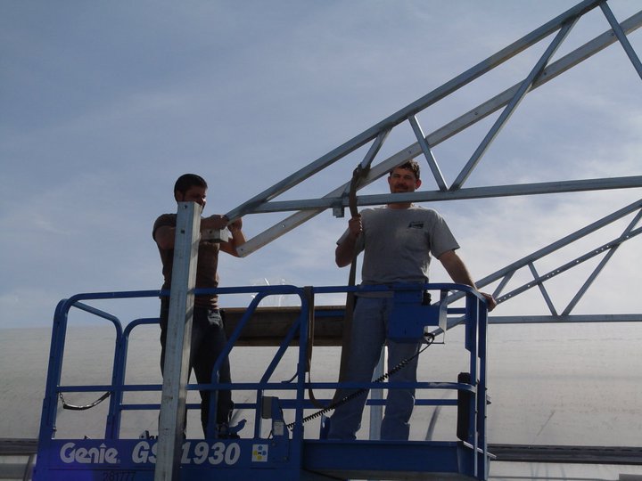Two men using construction equipment