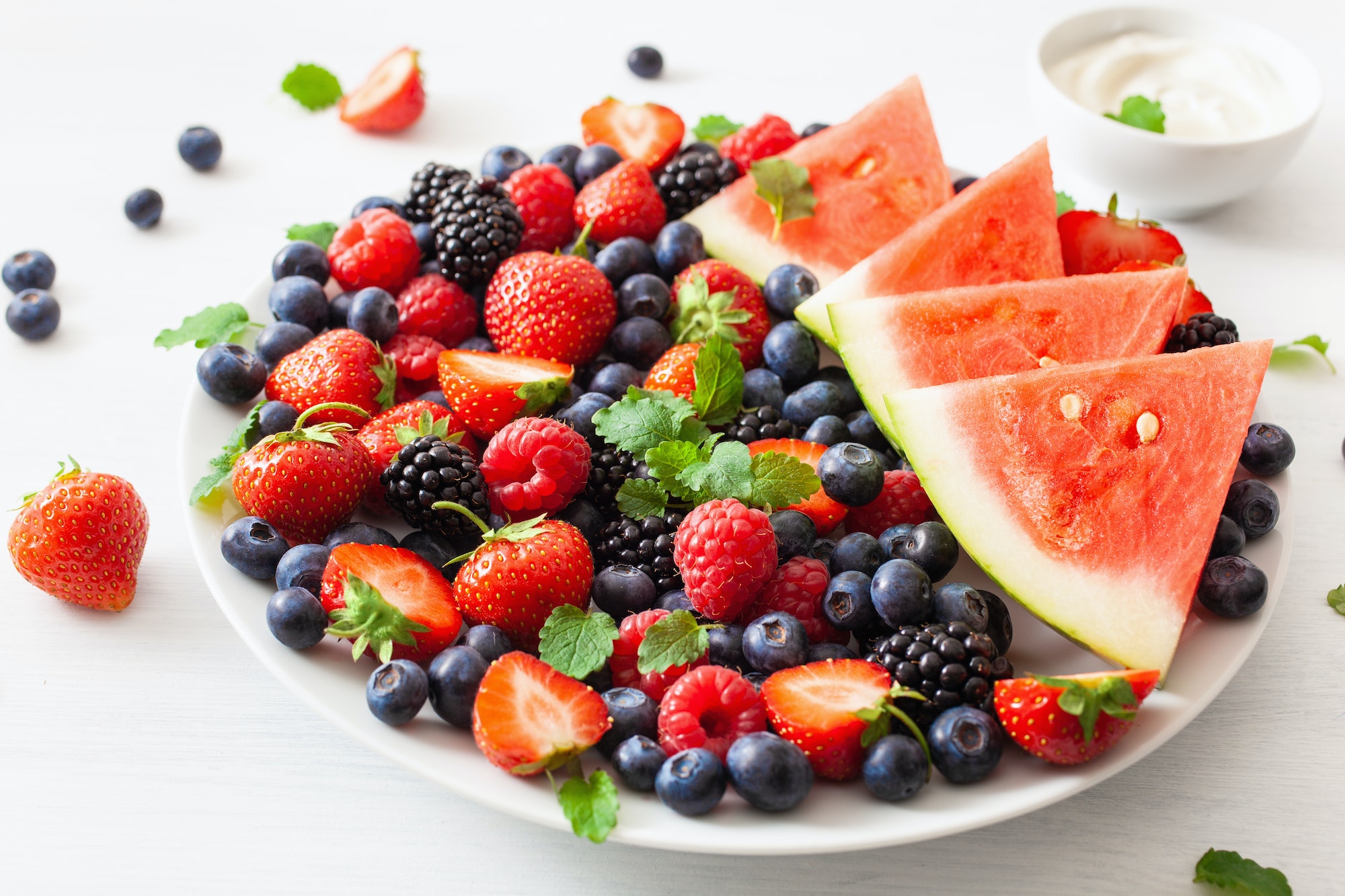 fruit and berry platter over white. blueberry, strawberry, raspb
