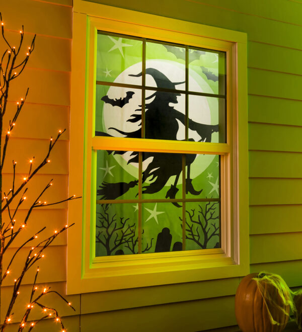 Evergreen Witch silhouette window shade inside window from outside with orange light up tree and pumpkin